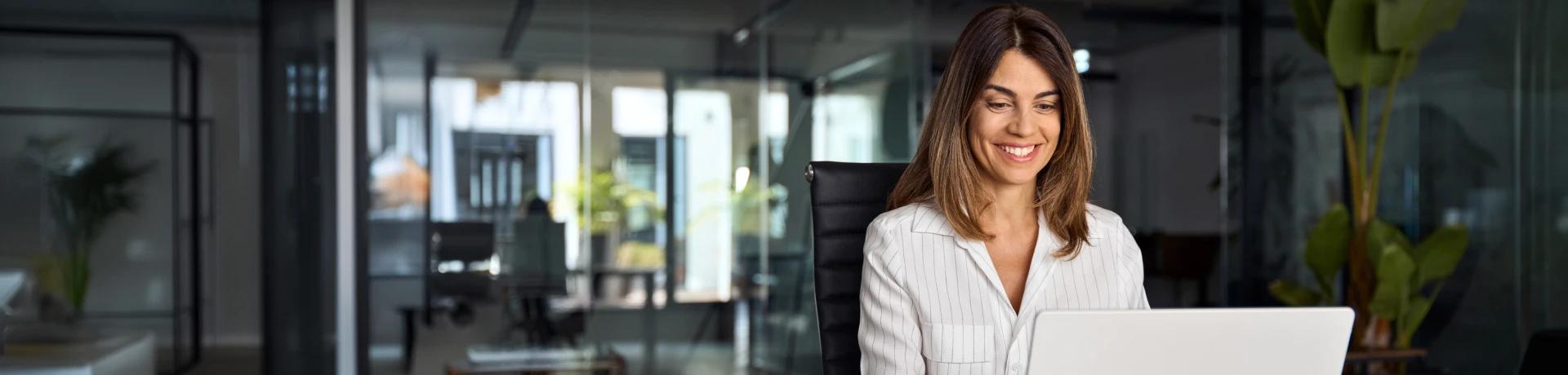Empresaria usando su laptop para abir una cuenta en Santander