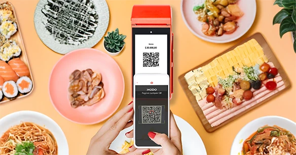 Celular con la App Santander sobre una mesa con diferentes platos de comida